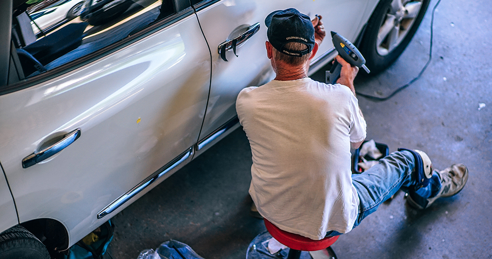 Mann som reparerer bil. Foto.